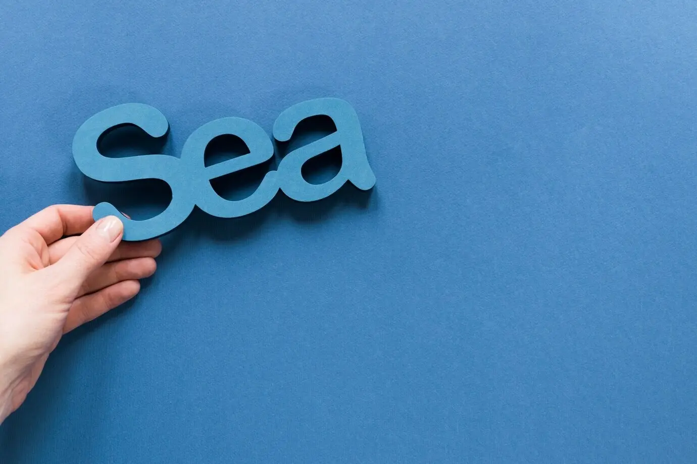 Draufsicht auf eine Hand, die das Meer hält, mit Platz für Text.